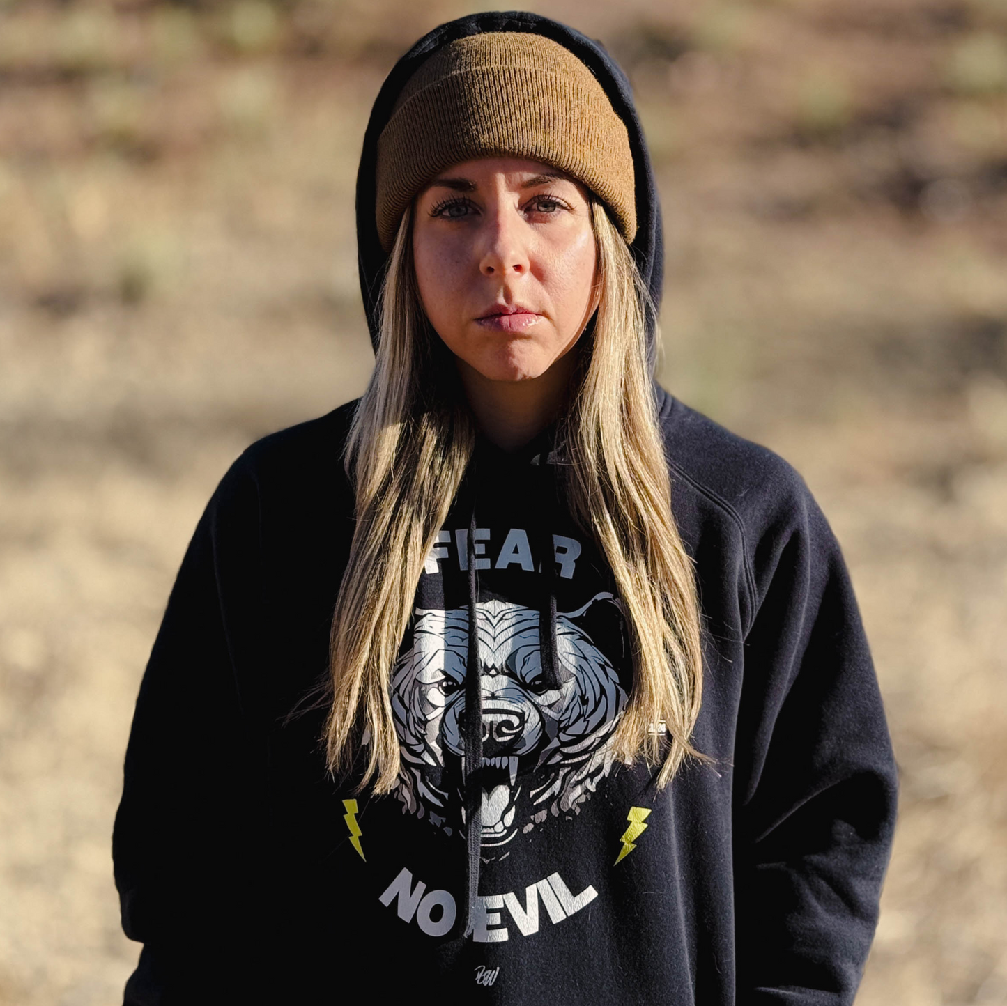 A girl wearing the fear no evil bear hoodie and a brown beanie
