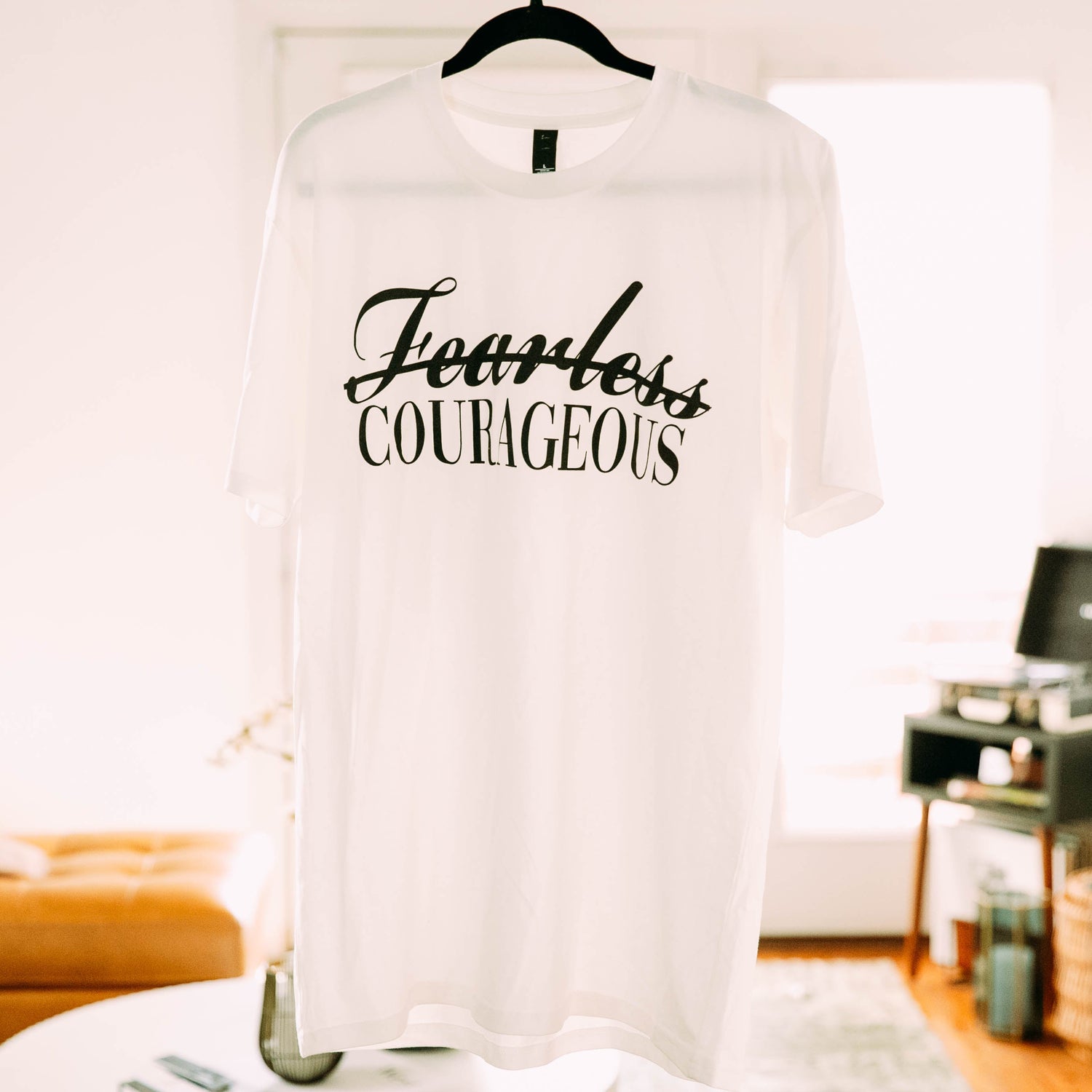 Courageous is not fearless t shirt in a living room