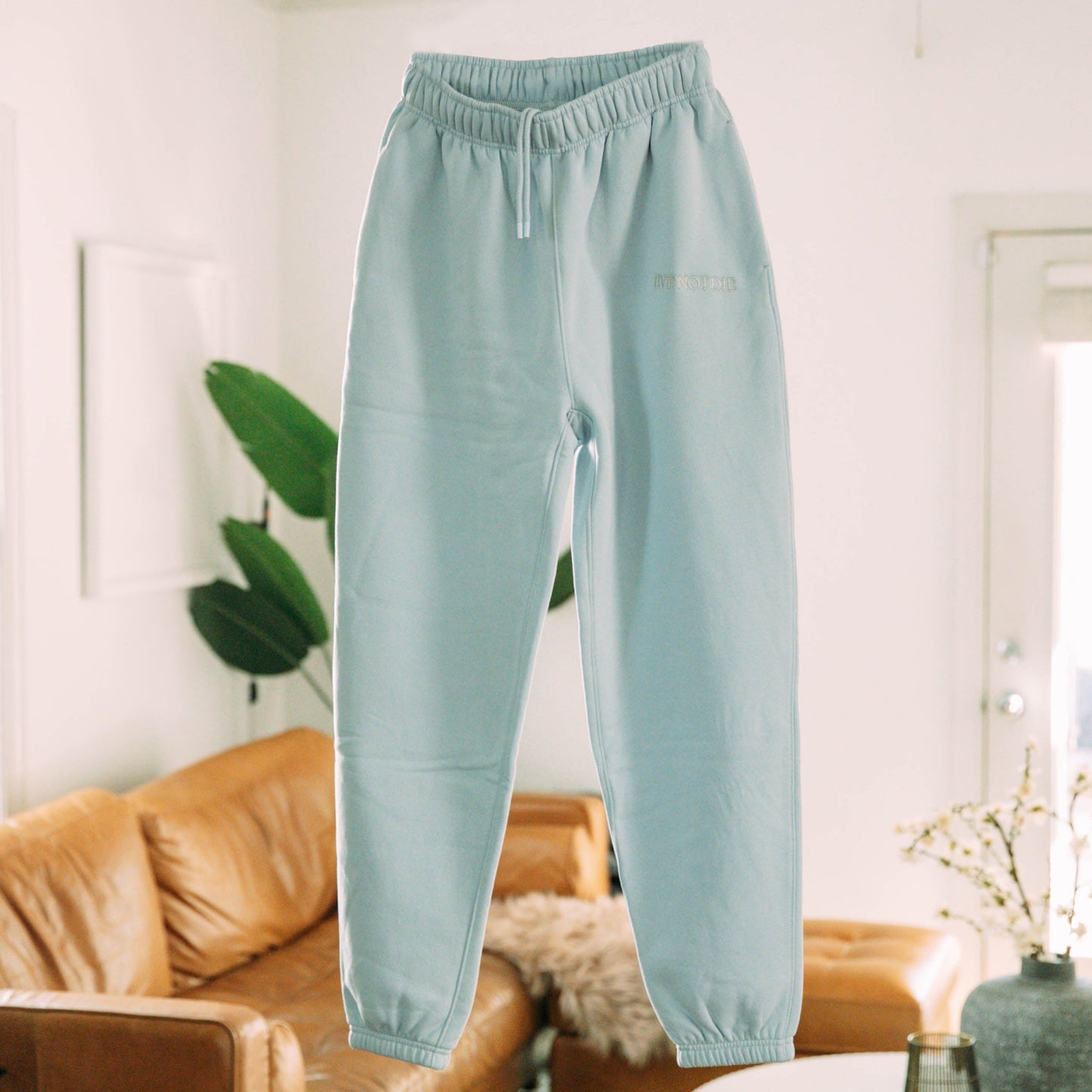 A product shot of the live not die trackpants