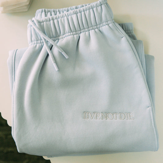 A product shot of the live not die trackpants