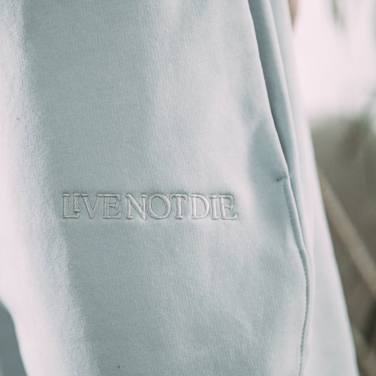 A product shot of the live not die trackpants